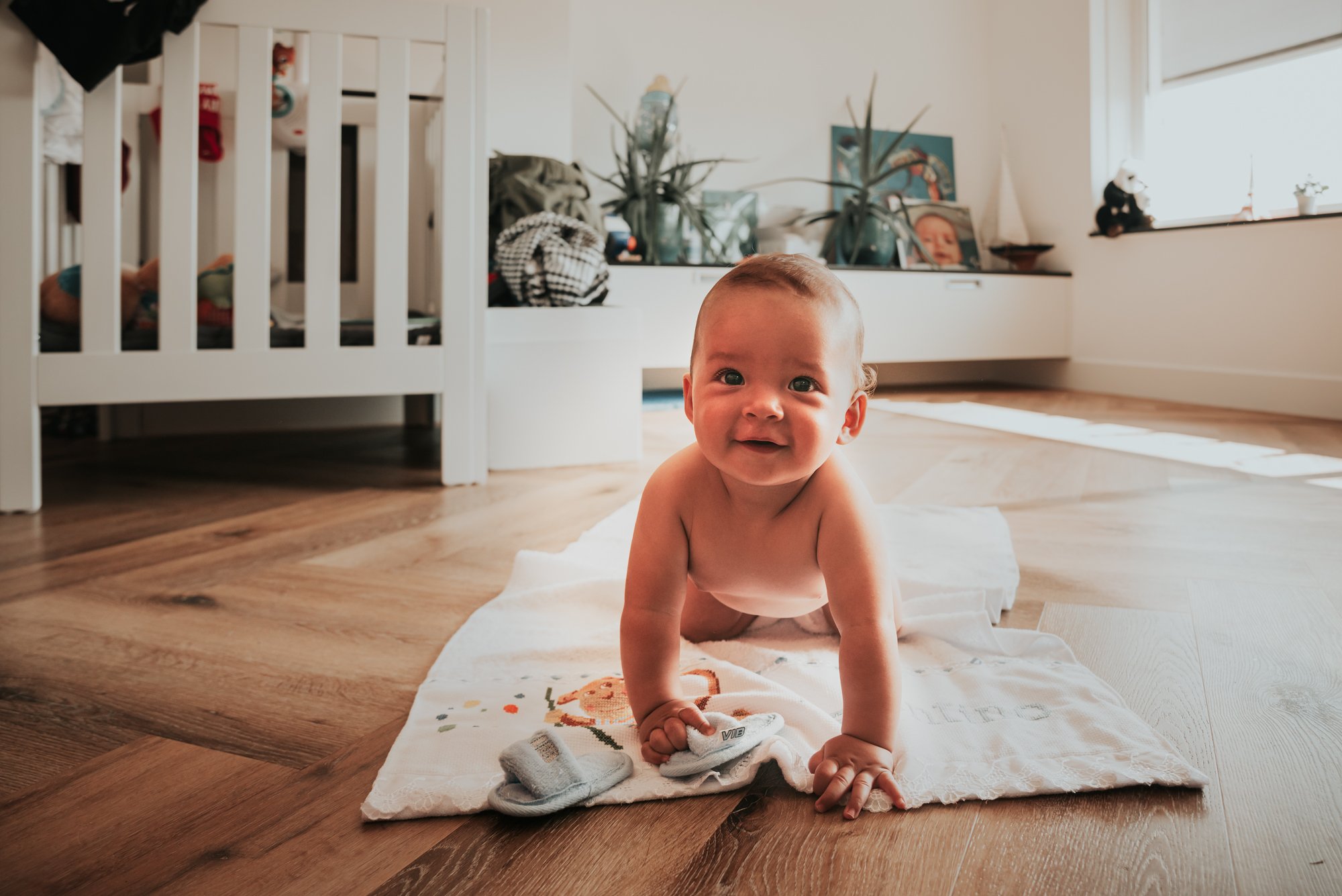 Happy baby crawling on floor at home lifestyle photography session Netherlands Ka Monge