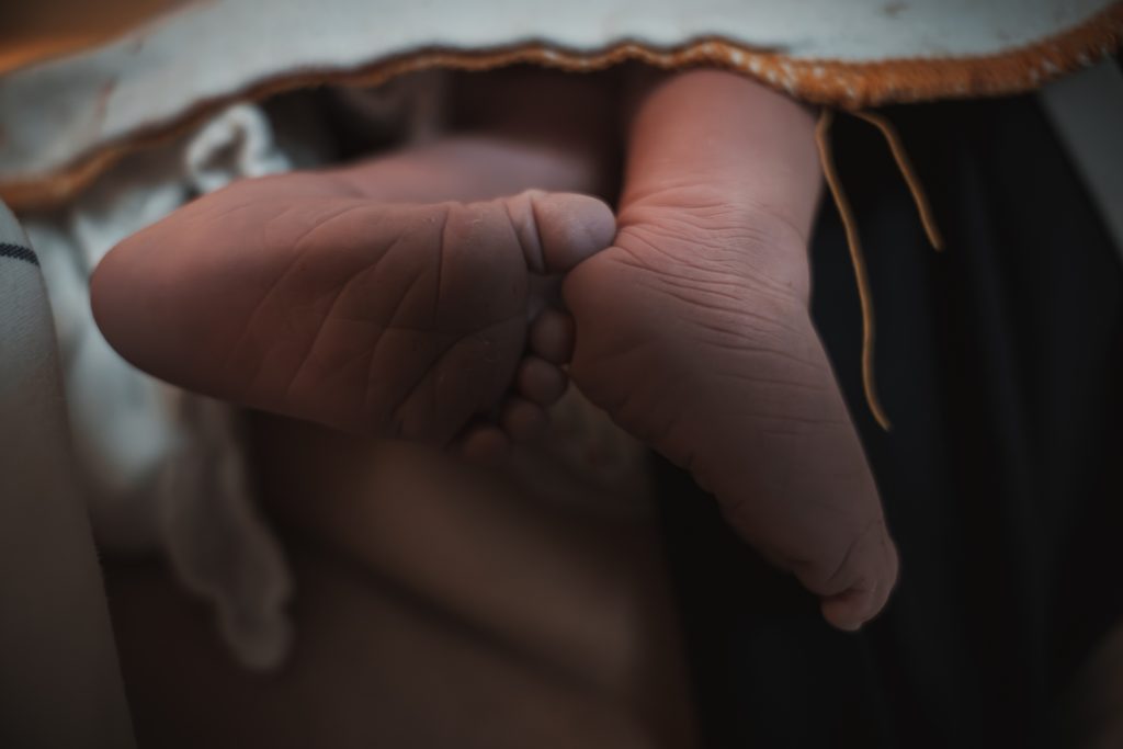 Close-up of a newborn baby's tiny feet moments after birth