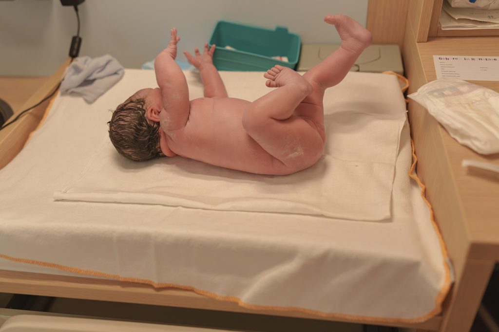 Newborn baby girl on the warming table after a hospital birth in Arnhem