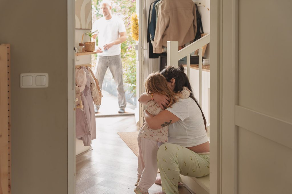 Mother in labour leaning on her partner at home, doula support Netherlands