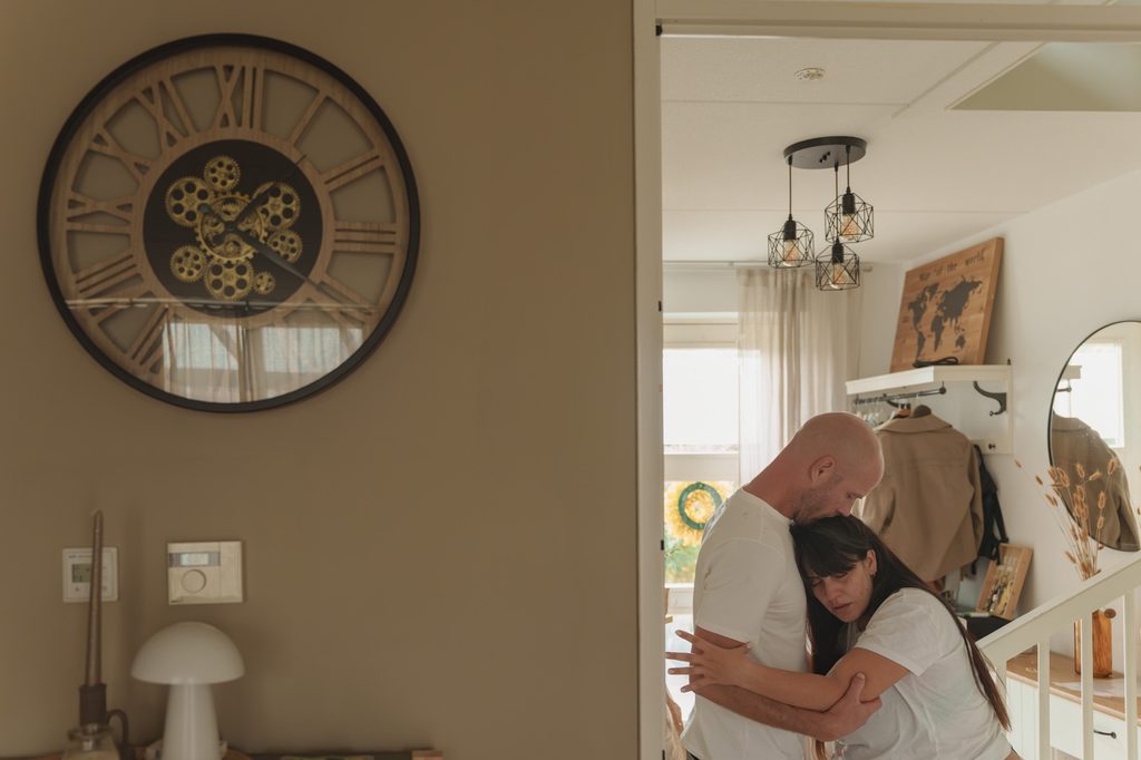 Couple hugging at home during early labour, documentary birth photography Netherlands