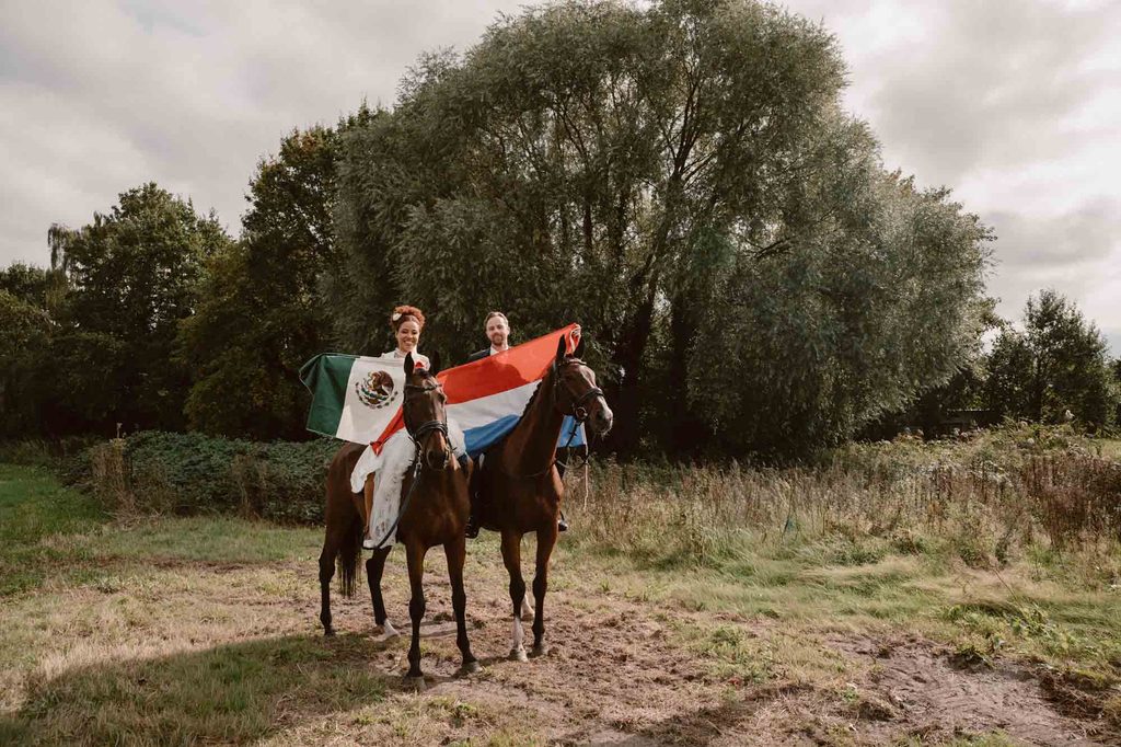 Bride and groom with a horse in the field, Mexican-Dutch wedding in the Netherlands