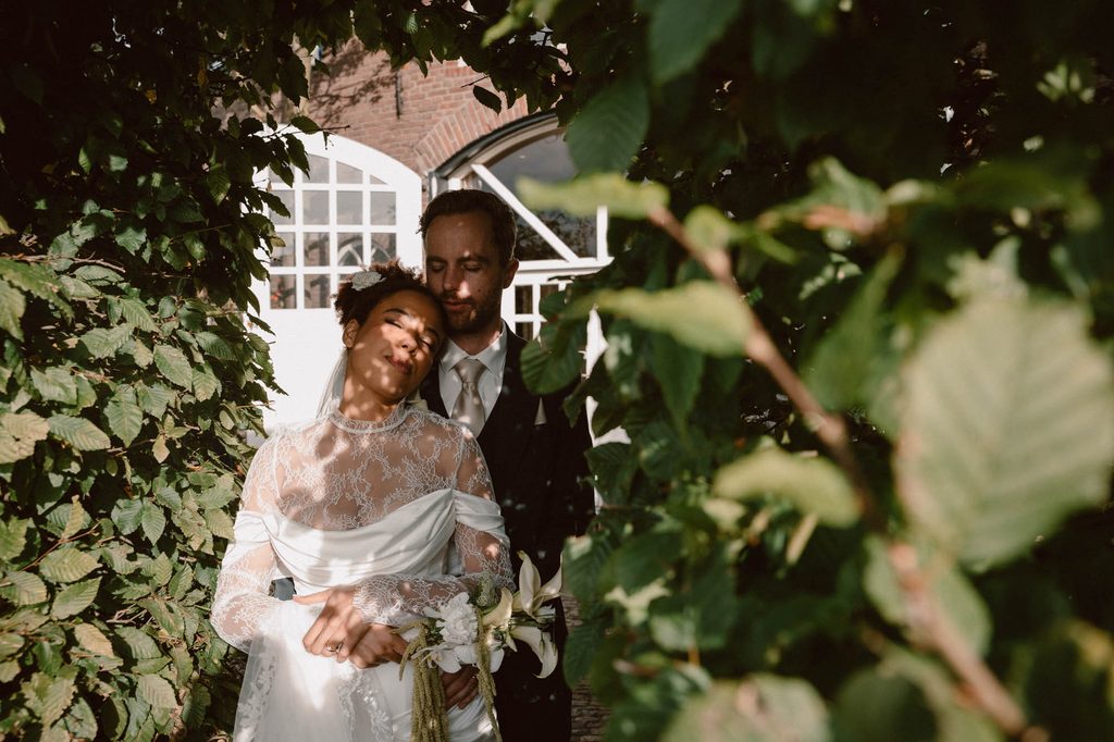 Bride between green leaves, wedding portrait, Mexican-Dutch wedding in the Netherlands