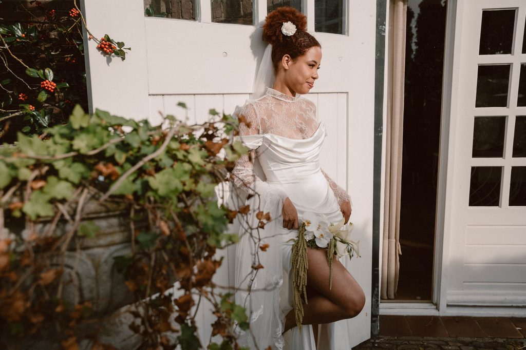 Bride ready at the window before the ceremony, Mexican-Dutch wedding in the Netherlands