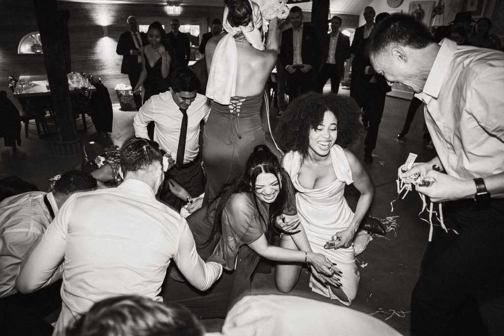 Family and friends cheering at the piñata, black and white, Mexican-Dutch wedding in the Netherlands