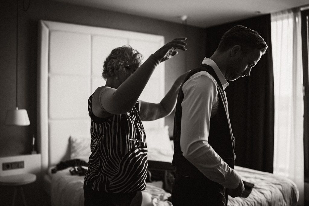 Groom getting ready with help from a friend, Mexican-Dutch wedding in the Netherlands