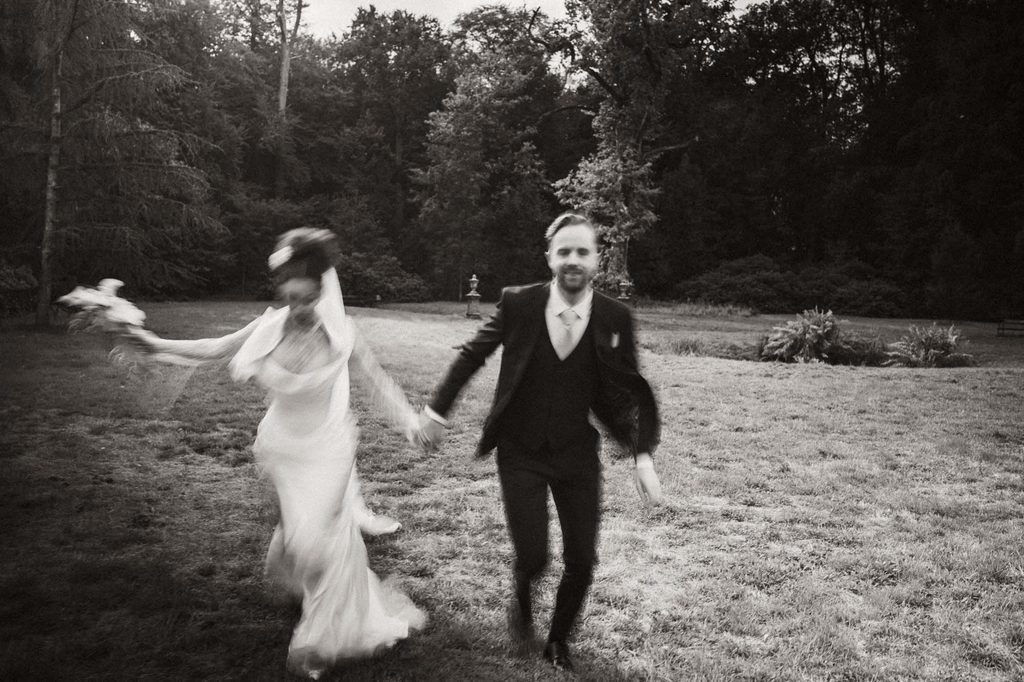 Bride and groom laughing as they walk together, black and white, Mexican-Dutch wedding in the Netherlands